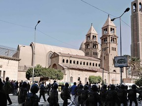 Egyptian security forces walk in front of St. Mark Cathedral in central Cairo, following a bombing, Sunday, Dec. 11, 2016. (AP Photo/Nariman El-Mofty)