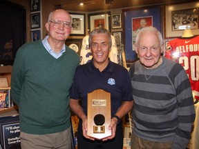 Brian Conacher (left), a member of the last Leaf Cup team in 1967, poses with 'Ultimate Leafs Fan' Mike Wilson (centre) and Pete Conacher (right). Pete's father, Charlie Conacher, scored the first Toronto goal at Maple Leaf Gardens on Nov. 12, 1931. Wilson is holding Charlie's puck during "A Night With Toronto's First Family Of Hockey," at Wilson's home on Dec. 6. (DAN NICHOLSON/Handout/Postmedia Network)  
Dan Nicholson