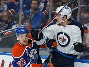 Oilers defenceman Matt Benning hits Jets forward Brandon Tanev during the first period of Sunday's game at Rogers Place. (Ian Kucerak)