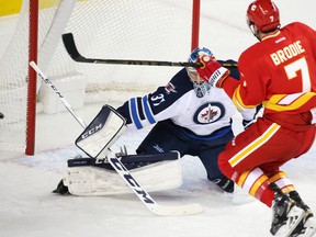 Calgary Flames TJ Brodie comes close to scoring on Winnipeg Jets goaltender Connor Hellebuyck during the third period of NHL action at the Scotiabank Saddledome in Calgary on Saturday December 10, 2016. GAVIN YOUNG/POSTMEDIA