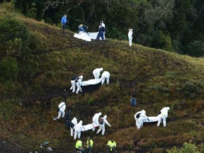 Rescue workers carry the bodies of victims of an airplane crash in a mountainous area near La Union, Colombia, on Nov. 29, 2016. (AP Photo/Luis Benavides, File)
