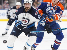 Connor McDavid battles against Mathieu Perreault during Sunday night's game. (Codie McLachlan/Getty Images)