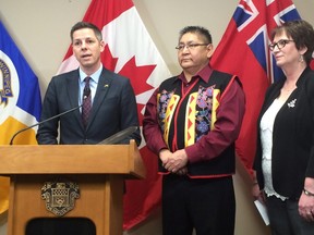 Winnipeg Mayor Brian Bowman, Shoal Lake 40 First Nation Chief Erwin Redsky and Manitoba Indigenous Affairs Minister Eileen Clarke speak to reporters at city hall on Monday about an agreement to build a road to Shoal Lake 40, an isolated reserve near the Manitoba-Ontario boundary. (THE CANADIAN PRESS/Steve Lambert)