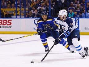 Winnipeg Jets' Josh Morrissey, right, skates with the puck as he is pressured by St. Louis Blues' Ryan Reaves during a game earlier this month. Armed with pens instead of hockey sticks, the NHL's future stars are learning about more than just power plays and puck possession. (THE CANADIAN PRESS/ AP/Billy Hurst)