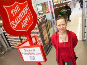 Free Press reporter Debora Van Brenk stands beside a Salvation Army collection kettle at the entrance to a Sobeys grocery store in London. Van Brenk says her brief experience underscored a sincere generosity on the part of Londoners to give and to share stories on the good works of the Salvation Army.  (CRAIG GLOVER, The London Free Press)
