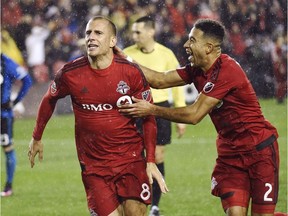 Toronto FC midfielder Benoit Cheyrou (8) celebrates his goal against the Montreal Impact with teammate Justin Morrow (2) during extra time of MLS Eastern Conference playoff soccer final action in Toronto on Wednesday, November 30, 2016. THE CANADIAN PRESS/Nathan Denette