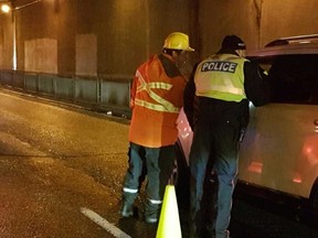 A Toronto Hydro worker hands out flashlights alongside police at a RIDE check in Toronto on Monday, Dec. 12, 2016. (@torontohydro)