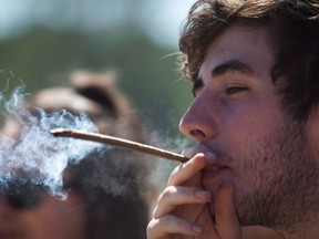A man smokes during the annual 4/20 cannabis culture celebration at Sunset Beach in Vancouver, B.C., on April 20, 2016. (THE CANADIAN PRESS/Darryl Dyck)