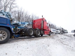 An overturned tanker trailer, carrying what police described as oily water waste, is seen in the centre median of Highway 401, west of Colonel Talbot Road, in London, Ont. on Tuesday December 13, 2016. Craig Glover/The London Free Press/Postmedia Network