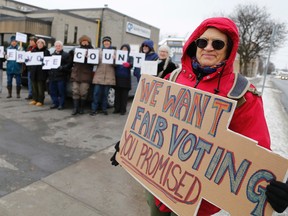 Jason Miller/The Intelligencer
Molly Mulloy holds a sign calling for fair voting outside the constituency office of Bay of Quinte MP Neil Ellis. Mulloy and other advocates rallied outside Ellis’ office in Belleville Tuesday.