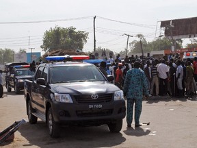 Emergency services, police and residents gather at the scene of a suicide bomb attack on a market in Maiduguri, Nigeria, after two girls approximately seven or eight years old blew themselves, killing themselves and wounding at least 17 others. (STRSTR/AFP/Getty Images)