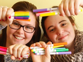 Luke Hendry/The Intelligencer
Autumn MacPherson, left, and Ashley Melvin hold markers at the Canadian Mental Health Assoc. office in Belleville Tuesday. They're organizing a Dec. 18 attempt to break a world record attempt for the most people colouring in one place at the same time. Admission is by minimum $5 donation to the United Way.