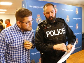 Matt Winch is one of a number of drinkers at a special Christmas party in Newmarket sponsored by York Region Police to measure effects of drinking on a group of volunteers on Dec. 13, 2016. Here he goes over his readings with Const. Mark Hawley. (Michael Peake/Toronto Sun)