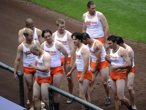 In this Sept. 17, 2008, file photo, Padres rookies are dressed like Hooters servers as part of rookie hazing after the Padres' 1-0 loss to the Rockies at Coors Field in Denver. That hazing ritual of dressing up rookies as Wonder Woman, Hooters Girls and Dallas Cowboys cheerleaders is now banned by Major League Baseball. (John Leyba/The Denver Post via AP)