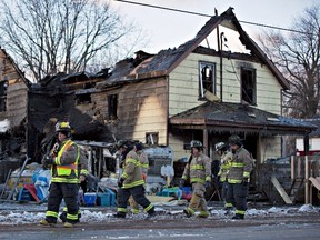 Firefighters survey the damage to a home in Port Colborne, Ontario, where a fire broke out overnight, leaving one person dead and three others who are believed to be part of the same family unaccounted for, on Wednesday, December 14, 2016. (THE CANADIAN PRESS/Aaron Lynett)