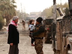 Civilians welcome Iraq's elite counterterrorism forces after an operation to liberate them from Islamic State militants at a recently liberated neighborhood in Mosul, Iraq, Tuesday, Dec. 13, 2016. (AP Photo/Hadi Mizban)