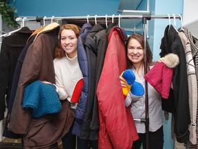 Charlotte Heller, left and Heather Poechman show off some of the donated coats, hats and mitts in the new Queen's Winter Coat Exchange, stored in the Room of Requirement in the John Deutsch University Centre, in Kingston, Ont. on Tuesday December 13, 2016. The exchange offers and collects free winter outer wear for students in need. Julia McKay/The Whig-Standard/Postmedia Network
