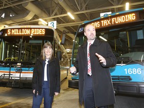 Kingston and the Islands MPP Sophie Kiwala and Kingston Mayor Bryan Paterson stand in front of a pair of city buses on Wednesday to mark both Kingston Transit's five-millionth passenger and the receipt of almost $2.34 million in provincial gas tax revenues. (Julia McKay/The Whig-Standard)