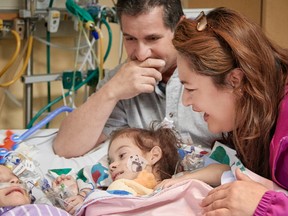In this Monday, Dec. 12, 2016, photo provided by the Lucile Packard Children's Hospital Stanford, the formerly conjoined twin girls, Eva, left, and Erika, right, reunite for the first time since separation surgery with their parents, Arturo Sandoval and his wife, Aida, in Palo Alto, Calif. On Monday afternoon, their intensive care team and parents carefully placed them side-by-side, carrying Erika, right, to Eva's bed to say hello. It's the closest proximity they've had since they were separated on Dec. 6. The 2-year-old Sacramento area girls were born conjoined from the chest down and shared a bladder, liver, parts of their digestive system and a third leg. (Lucile Packard Children's Hospital Stanford via AP)