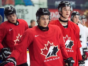 Canada's Dylan Strome, left to right, Mathew Barzal and Julien Gauthier wait for their turn as the world junior selection camp opens, in Boisbriand, Que., on Sunday, December 11, 2016. THE CANADIAN PRESS/Ryan
