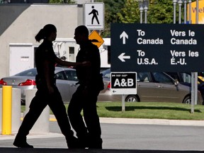 Canadian border guards are silhouetted as they replace each other at an inspection booth at the Douglas border crossing on the Canada-U.S. border in Surrey, B.C., on Thursday Aug. 20, 2009. The number of Americans seeking refugee status in Canada has experienced a significant bump this year, increasing more than five times in November 2016 from the same period a year earlier. (THE CANADIAN PRESS/Darryl Dyck)