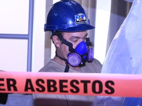 Rory O'Rourke carries out asbestos cleanup in an area which once served as a public washroom at Hastings County's Pinnacle Street administration building in Eastern Ontario. (Jason Miller/Postmedia)