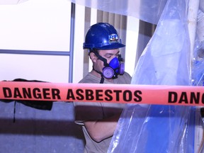 Rory O'Rourke carries out asbestos cleanup in an area which once served as a public washroom at Hastings County's Pinnacle Street administration building in Eastern Ontario. (Jason Miller/Postmedia)