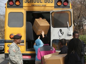 Brainerd High School JROTC students help load boxes of the Talley Road memorial items from the scene of a school bus crash that killed several Woodmore Elementary Students, into a school bus on Dec. 14, 2016. (Dan Henry/Chattanooga Times Free Press via AP)