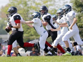 Rideau Redblacks slotback Cole Lalonde drags Nepean Eagles defensive back Owen Keenan down the field during mosquito action in the National Capital Amateur Football Association at Commonwealth Field on Monday September 7, 2015. DARCY CHEEK/THE RECORDER AND TIMES