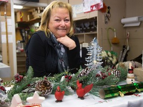 MaryAnn Verberne of McLennan Flowers in Lambeth has an assortment of Christmas themed decorations. (MIKE HENSEN, The London Free Press)