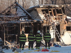 Fire fighters and Ontario Fire Marshall officials attend the scene of a house fire on Oneida Nation of the Thames, southwest of London, Ont., Thursday Dec. 15, 2016. (THE CANADIAN PRESS//Dave Chidley)