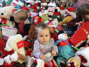 Checking out the gift-filled stockings donated to the Better Beginnings program at the Kingston Community Health Centres on Weller Avenue in Kingston on Thursday are, from left, Ava Freeman, Laura McCarthy and Natalie Stillwell. (Michael Lea/The Whig-Standard)