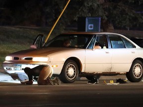 In this July 6, 2016 file photo, Investigators search a car at the scene of a police involved shooting in Falcon Heights, Minn.  (Leila Navidi/Star Tribune via AP, File)
