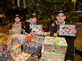Jack Vanderweyst, left, Lucas Diponio and Jacob Zaifman show some of the  shoeboxes their team has filled with gifts for My Sister?s Place and other charities. (MIKE HENSEN, The London Free Press)