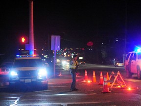 A Washington State Trooper directs traffic around a roadblock near Skagit Valley College in Mount Vernon, Wash., Thursday, Dec. 15, 2015. A Mount Vernon Police officer was shot and critically wounded by a suspect who was then barricaded in a Mount Vernon residence, authorities said. (Brandy Shreve/Skagit Valley Herald via AP)