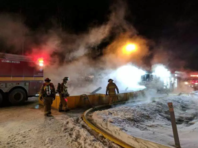 Firefighters are surrounded by vapour as they battle a fire on Hedley Way in Kanata Friday, Dec, 17