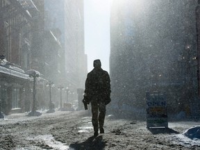 A pedestrian walks through blowing snow and wind along the Sparks Street Mall in Ottawa