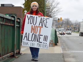 Ashely Smith holds a sign at the Zonta Club's demonstration Nov. 25, Say No on the Bridge. More than three dozen people showed up to wear orange and brave the chilly late-November weather in downtown Chatham for the International Day for the Elimination of  Violence Against Women.