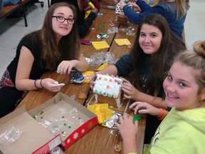 Grade 9 students decorating their gingerbread house in the CECI cafeteria Tuesday.