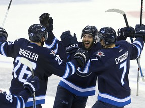 Mathieu Perreault (centre) celebrates his game winning goal in a shootout against the Florida Panthers with right winger Blake Wheeler and defenceman Ben Chiarot on Thursday night. (Brian Donogh/Winnipeg Sun)