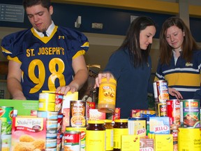 Pictured sorting donations for the Christmas Care Campaign are St. Joe's students Brice Beauregard, left, Reba Thompson and Jess White.