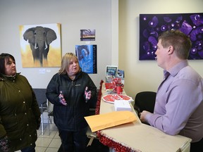 Gisele Dawson, left, president of CUPE Local 2841 representing laundry workers, and Sharon Richer, of the Ontario Council of Hospital Unions, speak to Brian Band, executive assistant at Sudbury MPP Glenn Thibeault's office in Sudbury, Ont. on Friday December 16, 2016. They delivered Christmas cards with letters from the laundry workers explaining the impact of losing their jobs. John Lappa/Sudbury Star/Postmedia Network