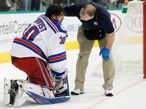 A trainer, right, checks on New York Rangers goalie Henrik Lundqvist (30) after a hit by Dallas Stars forward Cody Eakin during the first period of an NHL hockey game, Thursday, Dec. 15, 2016, in Dallas.