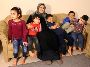Fatima Hacali is shown with her five children at her home in south London. From left are daughters Sedra and Esra Ahmed, and sons Luay, Kusay and Abdullah Ahmed. Hacali?s husband was killed in the Syrian war, leaving her to raise the youngsters on her own. A grateful Hacali says it is ?so wonderful to be in Canada.? (MIKE HENSEN, The London Free Press)