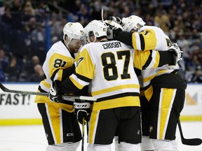 Pittsburgh Penguins center Sidney Crosby (87) celebrates with teammates, including Phil Kessel (81), after scoring against the Tampa Bay Lightning during the third period of an NHL hockey game Saturday, Dec. 10, 2016, in Tampa, Fla. (AP Photo/Chris O'Meara)