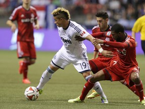 Vancouver Whitecaps FC Erik Hurtado (left) and Toronto FC Ashtone Morgan (right0 battle for the ball during the Amway Canadian Championship-semifinal game at BC Place in Vancouver, B.C. on Wednesday May 14, 2014. Carmine Marinelli/Vancouver 24hours