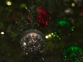 A news conference being held by the Prime Minister Justin Trudeau and indigenous leaders is reflected in a Christmas tree ornament in the foyer of the House of Commons on Parliament Hill in Ottawa, Thursday, December 15, 2016. THE CANADIAN PRESS/Adrian Wyld