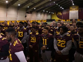 University of Minnesota wide receiver Drew Wolitarsky, flanked by quarterback Mitch Leidner, obscured behind Wolitarsky, and tight end Duke Anyanwu gestures as he stands in front of other team members while talking to reporters in the Nagurski Football Complex in Minneapolis, Minn., Thursday night, Dec. 15, 2016. (Jeff Wheeler/Star Tribune via AP)