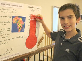 Evan Duggal, 12, updates his fundraising chart at his Bright's Grove home. The Grade 7 Bright's Grove Public student recently wrapped up a $5,000 fundraising campaign to support medical care in Zambia. Barbara Simpson/Sarnia Observer/Postmedia Network