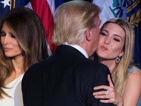 Donald Trump (C) kisses his daughter Ivanka Trump (R) as his wife Melania Trump (L) looks on after speaking during election night at the New York Hilton Midtown in New York on Nov. 9, 2016. (JIM WATSON/AFP/Getty Images)